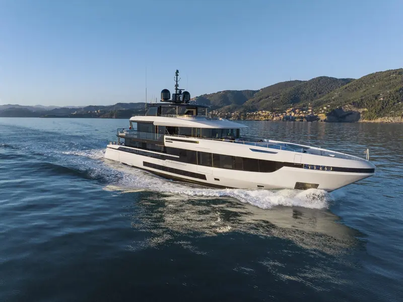 An Oceano 52 running hard off the Ligurian coast near Portofino, her wake showing the flare Mangusta gives the hull to keep the foredeck dry at speed.