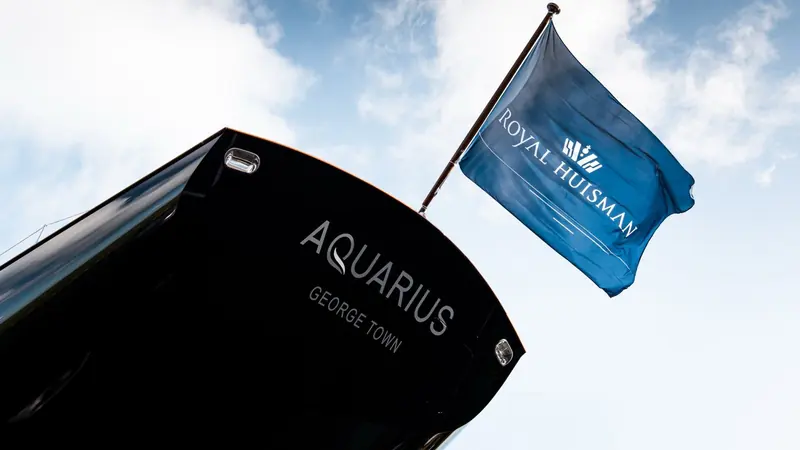 Aquarius's transom, her home port of George Town lettered beneath the name and the Royal Huisman burgee flying above - the builder's own confirmation of which yacht this pool shows.