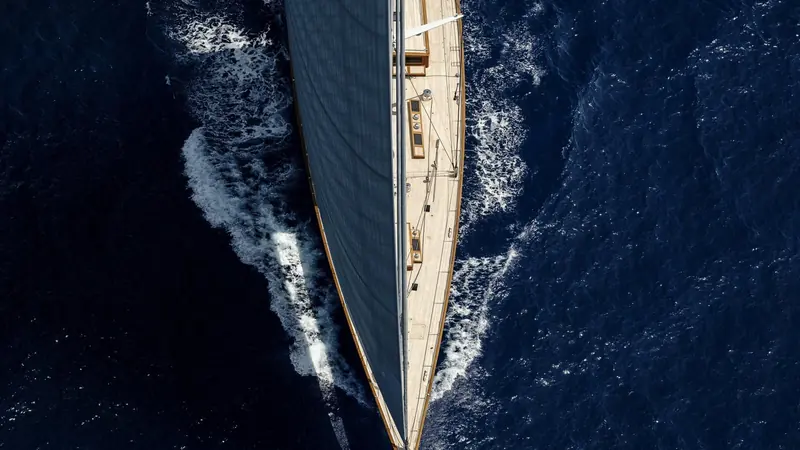 Close on the bow wave at speed, the fine entry that keeps a classic-style hull like this one competitive against modern designs.