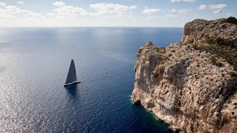 Running in past the cliffs near Cap Formentor, shown small against the rock to give a sense of her actual scale.