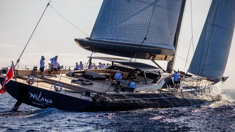 Nilaya of Valletta powering to windward under full sail, her hull lettering and homeport visible as the crew works the rail.