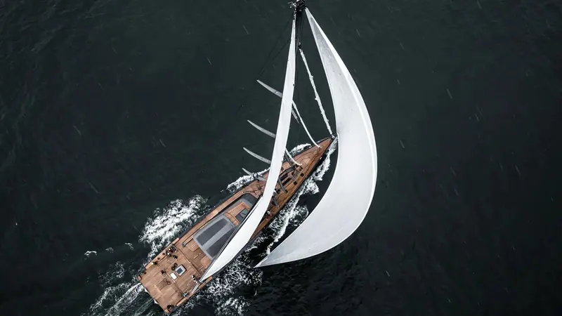 Overhead in a squall, spinnaker set and the teak foredeck streaked with rain - this is the Featherlight hull and rig that cut roughly a tenth of the weight out of a typical cruising yacht her size.