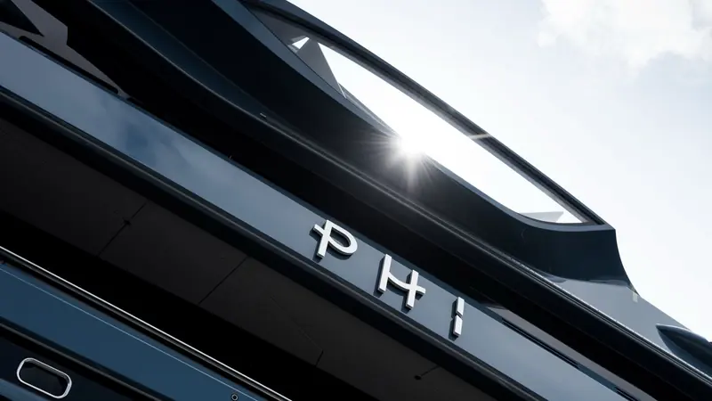 A closer angle on the same nameplate, showing the knife-edge coachroof line that gives PHI her spaceship silhouette on the water.