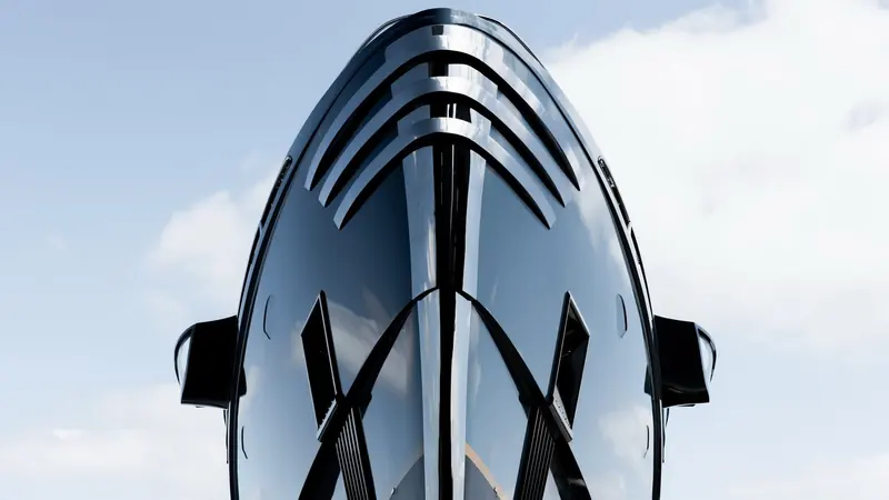 The mast cluster and radar arch seen from below, the dark composite structure at odds with the yacht's pale hull colour.