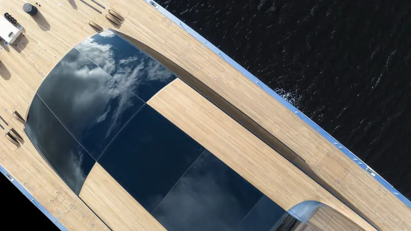 Looking aft along the flush foredeck, the smoked-glass coachroof panels reflecting the sky instead of interrupting the deck's clean lines.