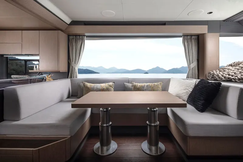 The dinette, glazed on three sides so the table doubles as a lookout when the boat is under way.