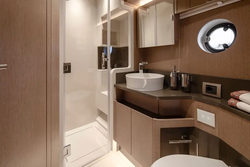 One of the ensuite heads, finished in a single dark wood run from vanity to shower door.