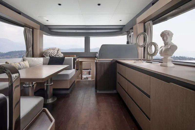 The saloon looking aft into the galley, dark oak flooring against lighter cabinetry.