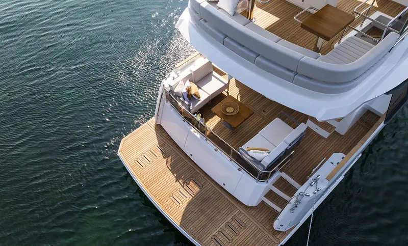 An aerial view of the flybridge shows the L-shaped lounge and helm seat sharing the space with a folding table, rather than the helm being walled off.