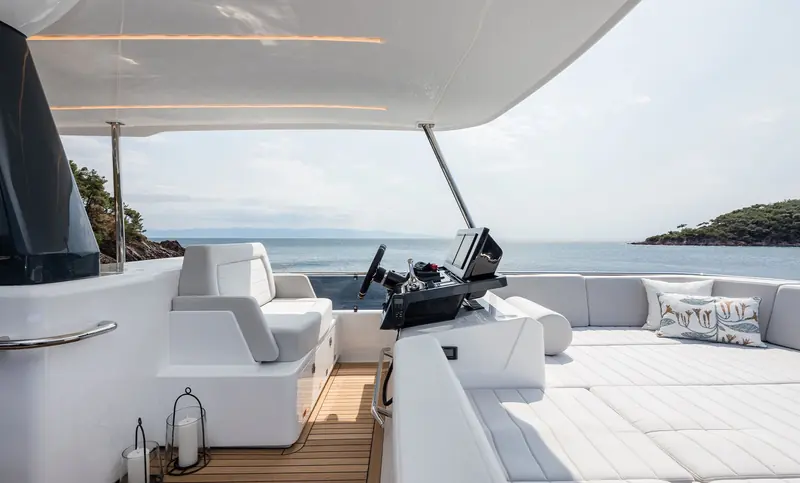 The flybridge helm, twin bucket seats facing a single MFD rather than the crowded multi-screen layouts common at this length.