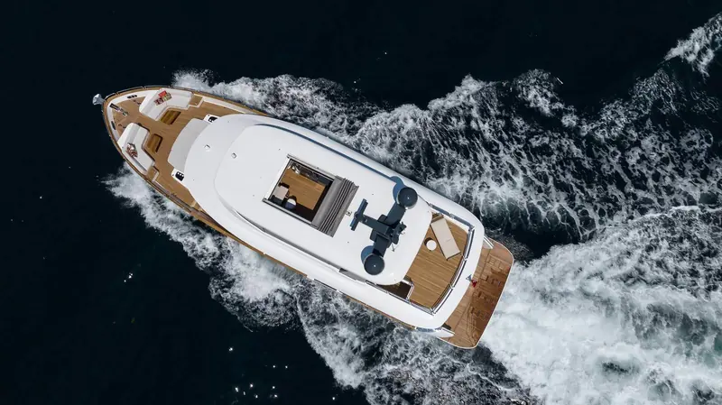 Running hard from directly overhead, the wake fanning out white against near-black water - this hull, named Serenity, at full chat.