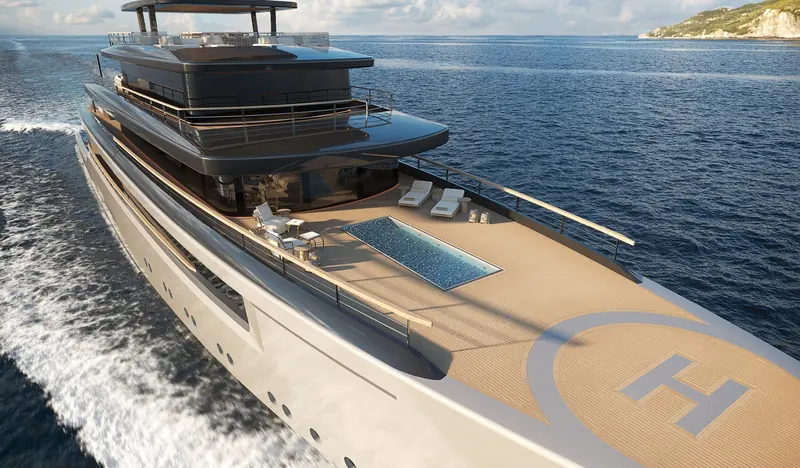 T700 Milano underway, bow wake breaking white as the foredeck pool and helipad marking pass beneath the wheelhouse overhang.