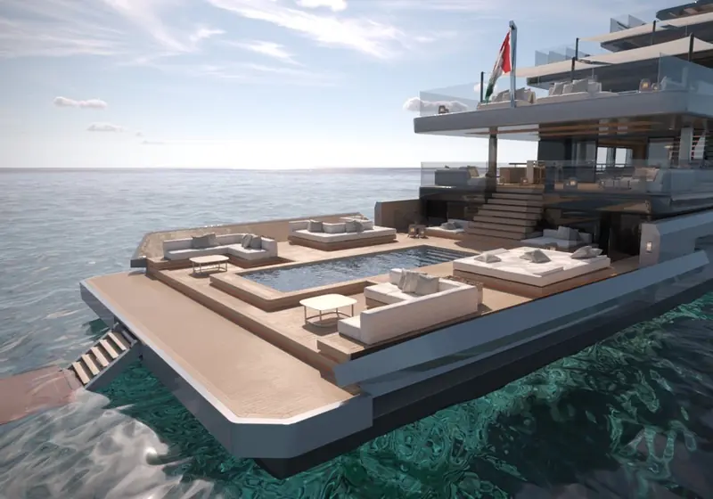 The swim platform lowers flush with the sea, turning the transom pool deck into a beach club with direct water access.