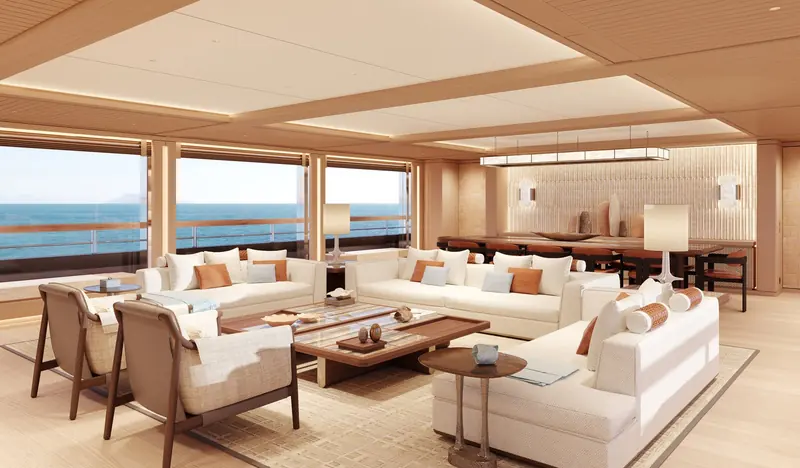 The main-deck salon, finished in warm oak with a low, wide seating arrangement that keeps sightlines open to the sea on both sides.