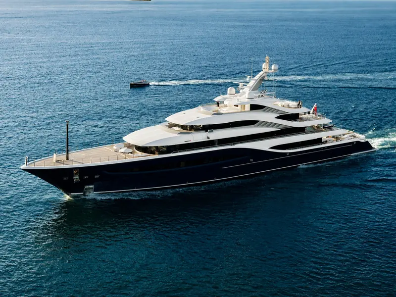Angelique seen from astern under power, a tender following in her wake.