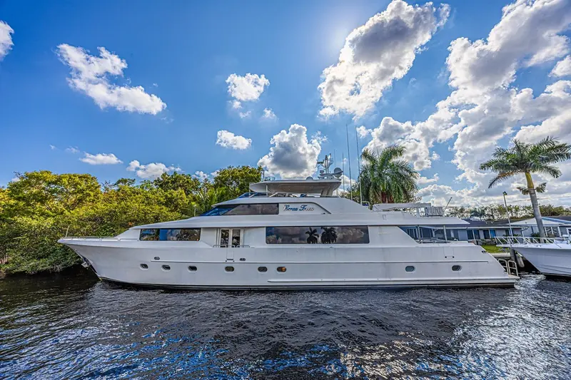 Cerca Trova docked on a Fort Lauderdale canal, palms and waterfront houses behind her and the Westport builder's plate visible below the pilothouse windows.