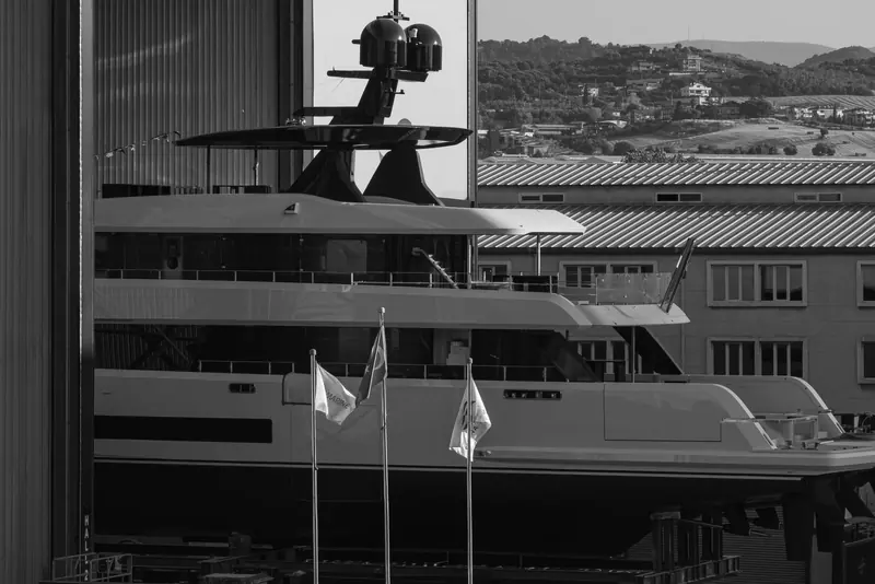 Framed against the shipyard's hillside surroundings near Istanbul, the flying bridge and radar arch take shape above the black-hulled superstructure.