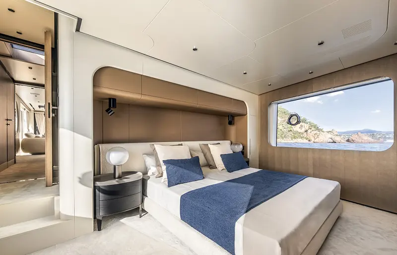 A double cabin aboard an Arcadia A80, with a window framing the coastline.