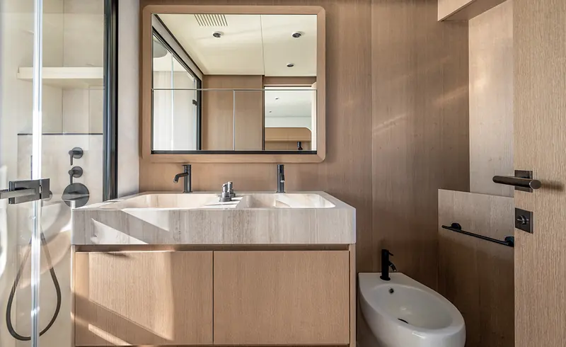 A cabin bathroom aboard an Arcadia A80, with a stone-topped double vanity.