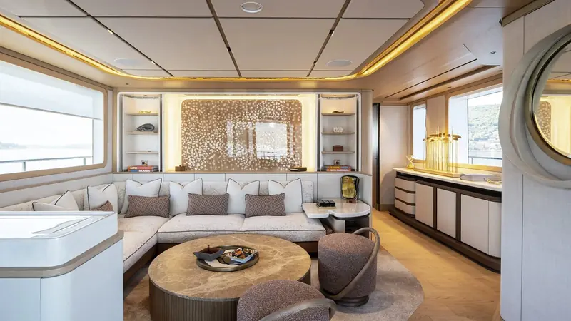 Inside, the saloon runs a warm, textured palette instead of the glossy white common on newer explorer yachts, true to the yard's now-settled house style.