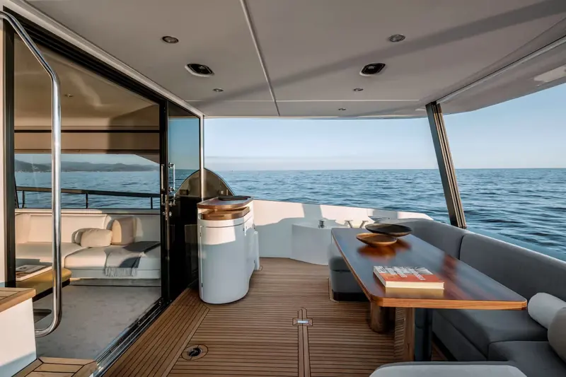 The main-deck salon of an Azimut Fly 68, another Achille Salvagni interior, opening aft through full-width glazing to the cockpit.