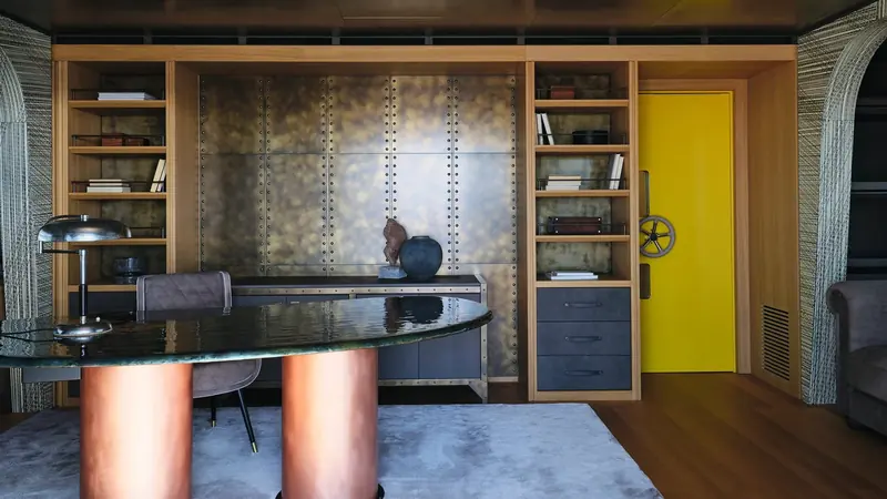 The study aboard Akula, riveted metal panelling and built-in shelving either side of a heavy door.