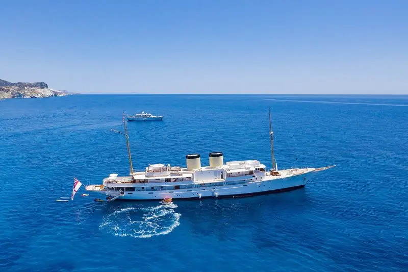 Anchored off Kleftiko on Milos in Greece, a classic twin funnel yacht works her tenders from the stern.