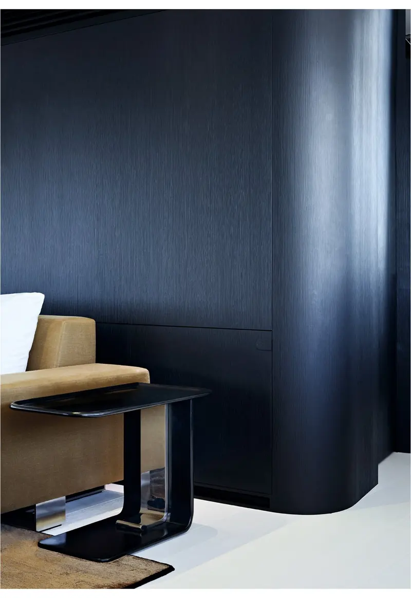 A cabin corner aboard Vertigo, showing the walnut, cream and black palette Liaigre built the interior brief around.