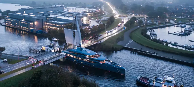 Phi, the 58.5 metre Royal Huisman motoryacht, departs the builder's Vollenhove yard through the road bridge at dawn in October 2021. At delivery she was the longest motoryacht in the world built under 500 gross tons.