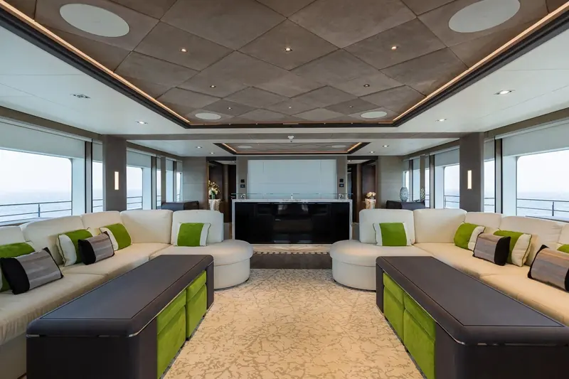The main saloon of the Majesty 175 (delivered 2021 as Serenity M.R.F.), interior and exterior both by Cristiano Gatto Design, the studio's largest completed volume to date, run with a single sightline from the aft doors to the forward bar.