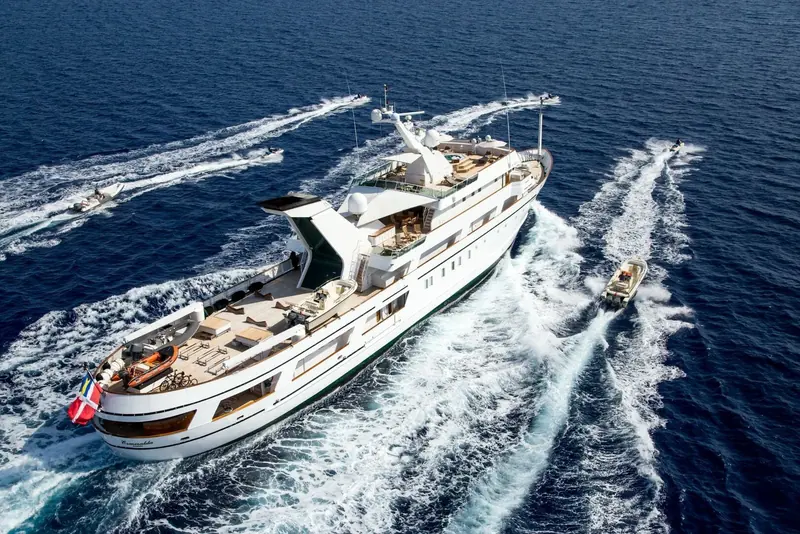 Esmeralda underway with a tender running alongside off her stern.