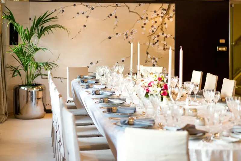 A formal dining table laid for guests below deck on Esmeralda, flowers and place settings ready.