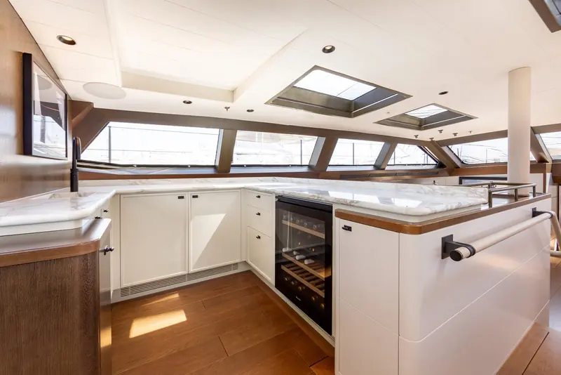 Ravenger's galley after the refit, finished in white and marble in place of the darker joinery it replaced, under the deckhouse skylights that are one of the Baltic 175's defining features.