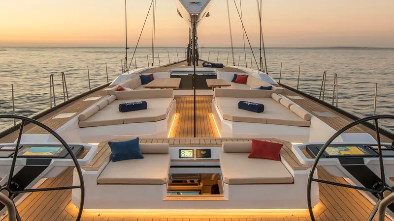 Satisfaction's twin-wheel cockpit and foredeck lounging at sunset, her name embroidered on the cushions (Southern Wind Shipyard).