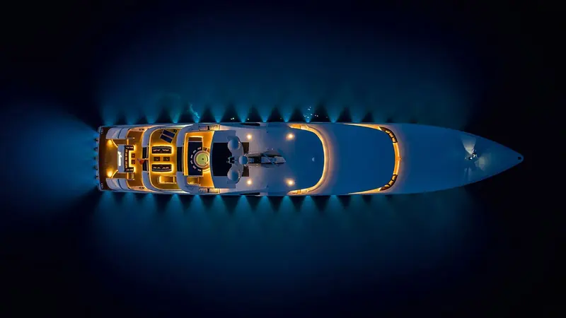 An aerial view of Soaring/Starlust's foredeck after dark, showing the clear bow lounge and sunpads Focus Yacht Design built into the 68.2 metre layout. The yacht won the International Superyacht Society's Best in Motor 1500-3000 GT award in 2023.