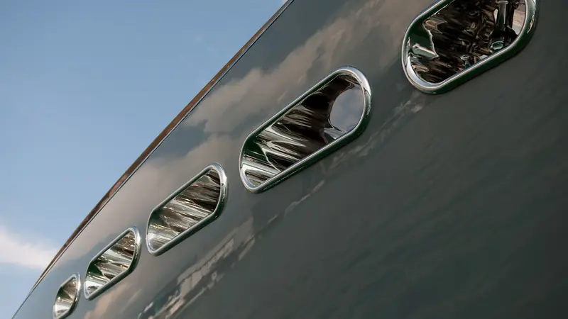 The row of oval portlights along a YachtPlus Signature Series hull, the 41m fractional-ownership motor yacht line Foster and Partners designed inside and out for Rodriquez Cantieri Navali.