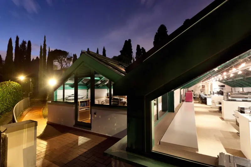 Paszkowski's studio outside Florence at night, a yacht model visible through the glass of the design office - the villa the practice has worked from for over two decades.