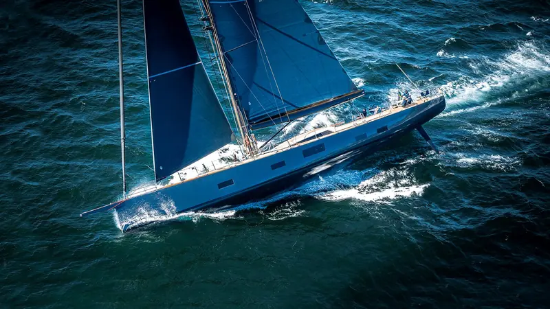Atomic heels into a turn, spray breaking off her bow as the crew works the foredeck.