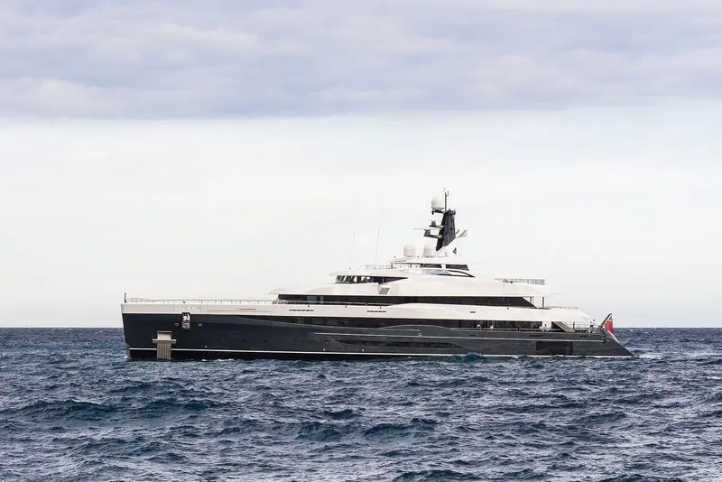 The dark-hulled 86-metre superyacht Elandess makes way off Monaco under an overcast sky.