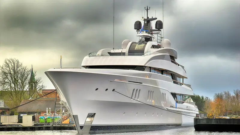 Vanish seen bow on at a quay under a heavy sky, the glazed deckhouse stepped back above a plumb stem.