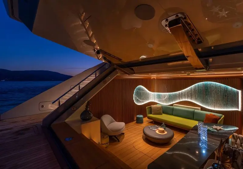 Warm light fills the aft deck lounge of Kasif after sunset.
