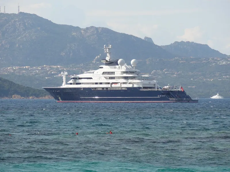 Octopus anchored off the coast of Sardinia, with a helicopter parked on the aft landing deck.