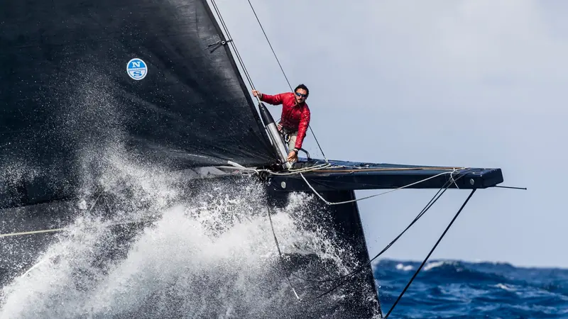 A crew member works the rail as Pink Gin VI drives hard to windward, her carbon rig and hull built by Baltic Yachts to Judel/Vrolijk's naval architecture.