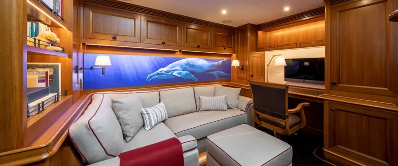 Path's study, lined in varnished joinery with a backlit photograph of a humpback whale and calf built into the panelling above the sofa.