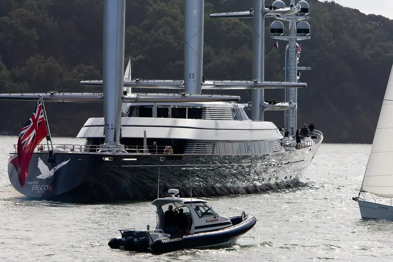 Maltese Falcon's stern, her name visible on the transom, with a tender standing by, off the Corsican coast.