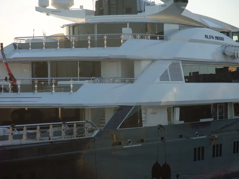 Close on the superstructure, the Oceanco builder's plate sits below the bridge deck rail of Alfa Nero.