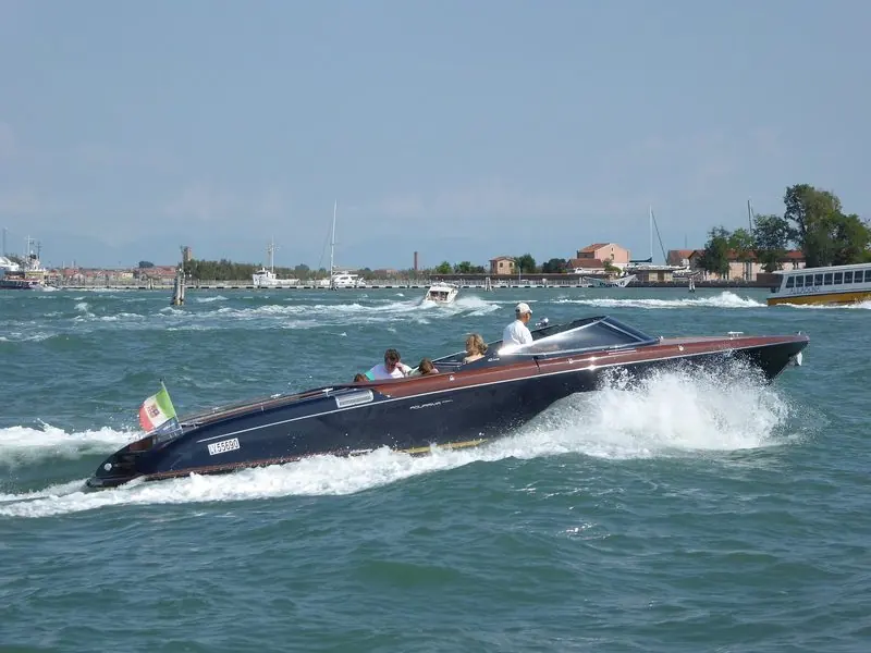 An Aquariva Super throws spray as she runs across the Venice lagoon.