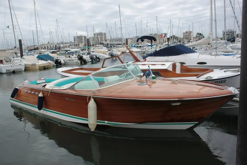 Fenders down, a wooden Riva sits alongside among the sailing boats at Arcachon.