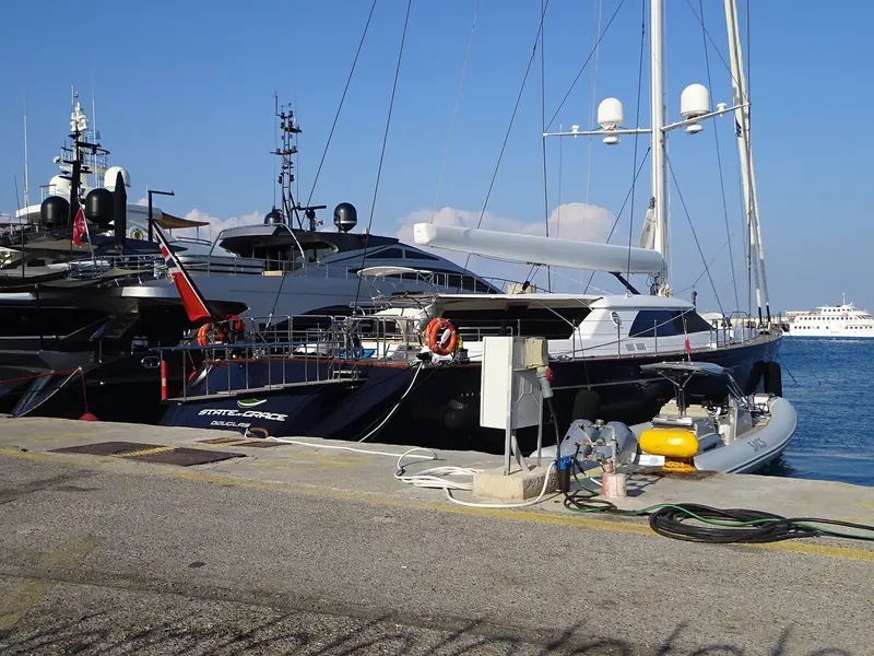 State of Grace at quay in Kolona Harbour, Port of Rhodes - the 73-metre motor yacht dressed for a Mediterranean call, her tender bay open to the dock.