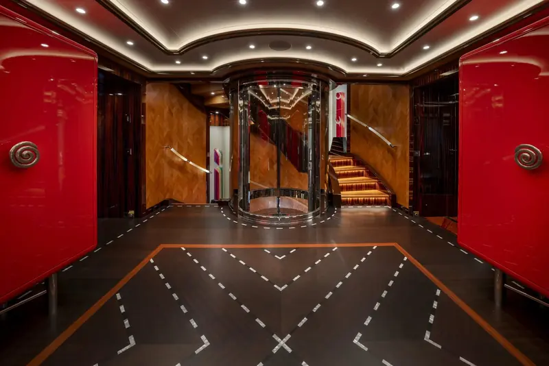 Alfa Nero's lacquered red entrance foyer, a signature piece of Pinto Art Deco showmanship built around the yacht's spiral stair and lift.